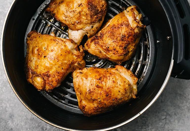 Four pieces of cooked chicken in an air fryer