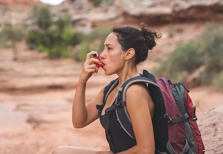 woman in her forties, using an inhaler