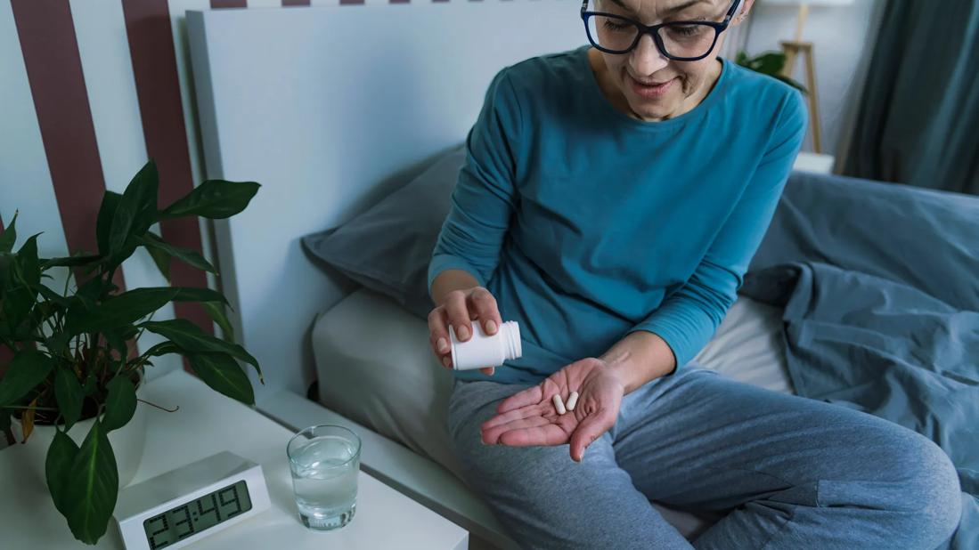 Woman taking medication before going to bed