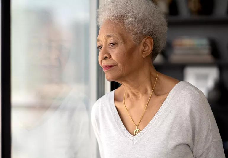 older woman sad looking out window