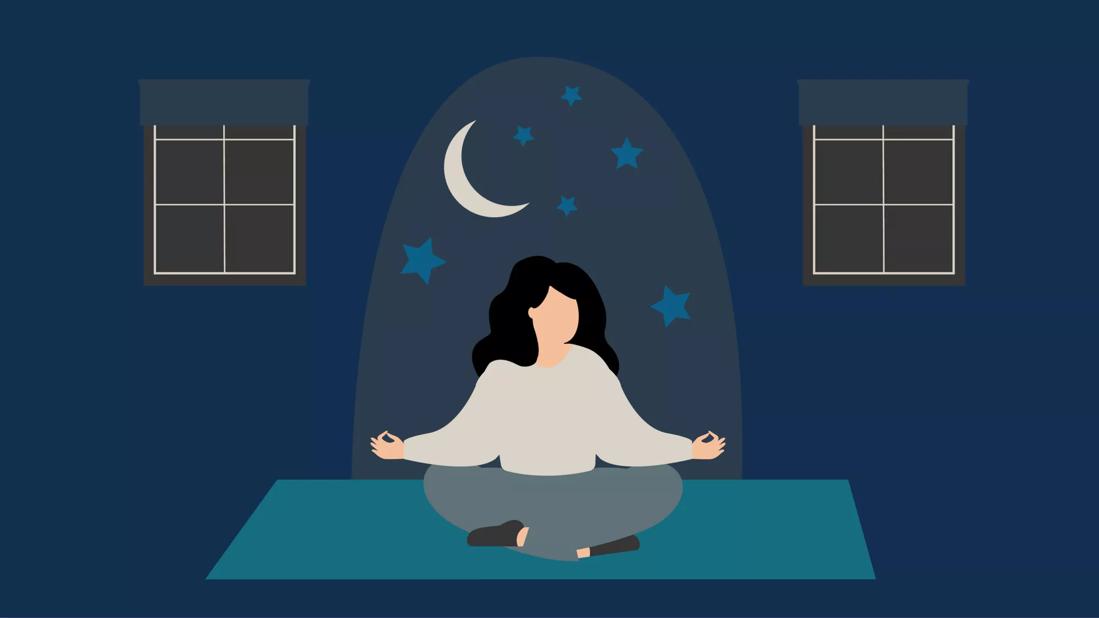 person practicing mindfulness at night time on a yoga mat