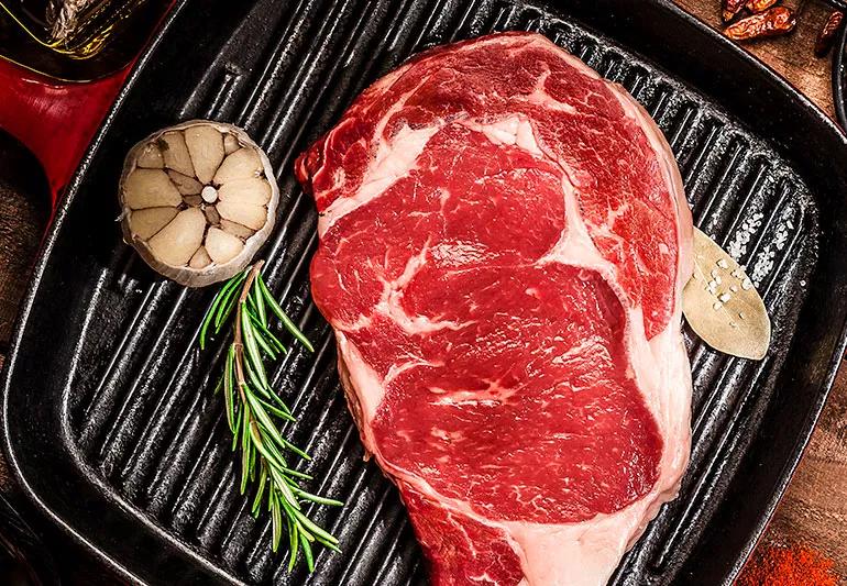 rare steak being prepped for grilling