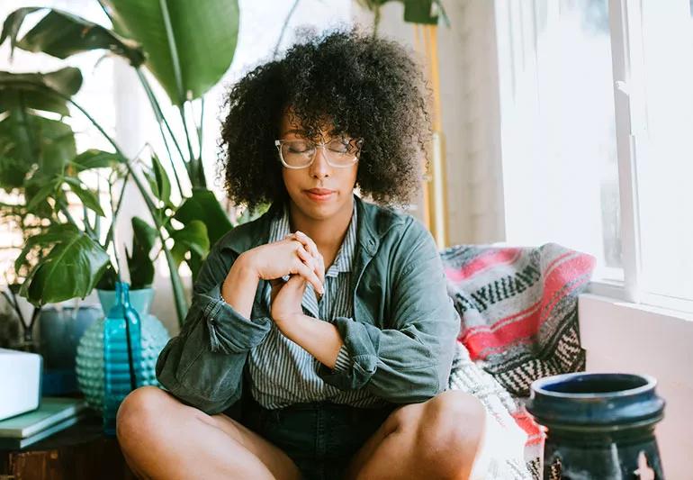 Woman meditating casually at home