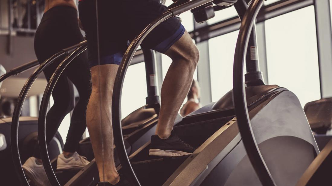 two people on vertical climbers at a gym