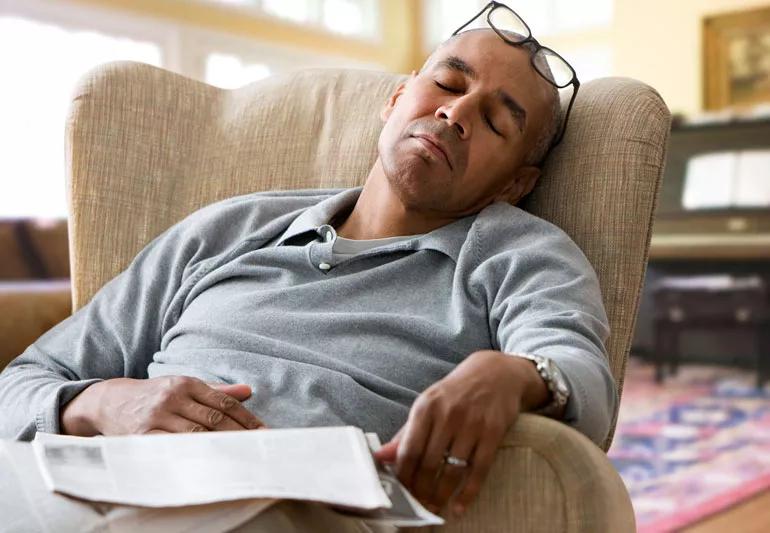 man sleeping in a chair during the day