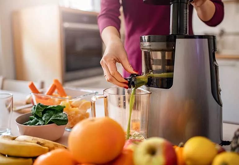 person juicing fruits and vegetables