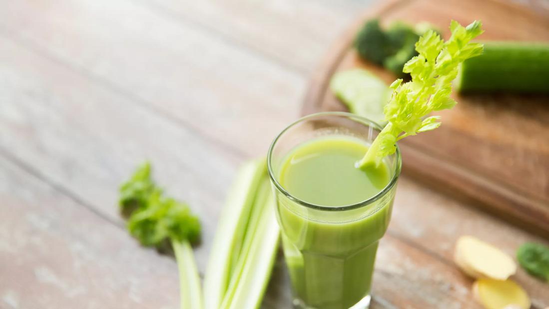 Glass of celery juice with stalk garnish