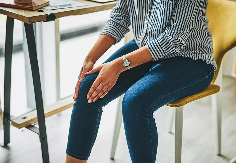 woman at desk with leg pain