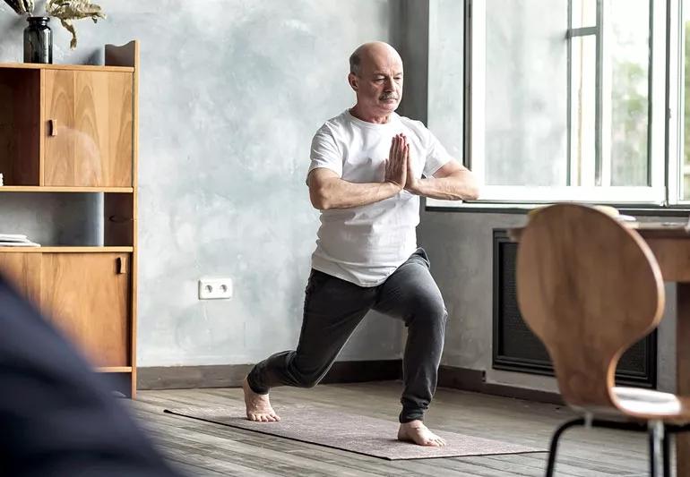 elderly man practicing yoga to destress
