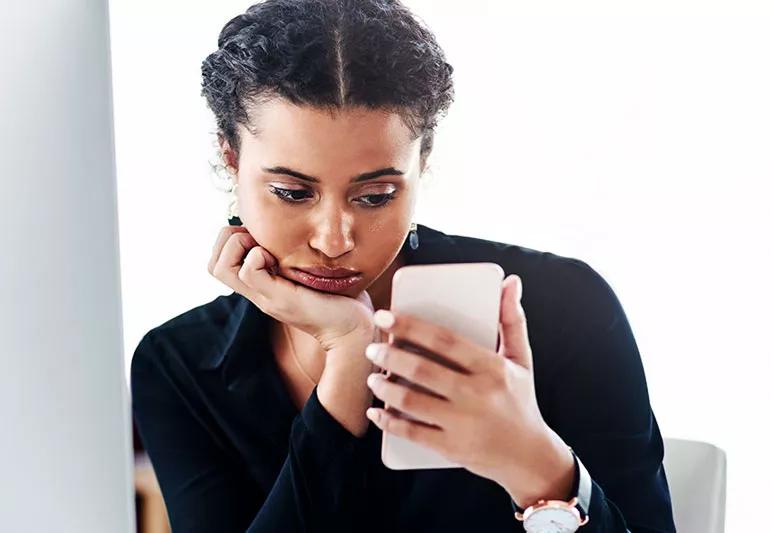 unhappy woman scrolling on smartphone