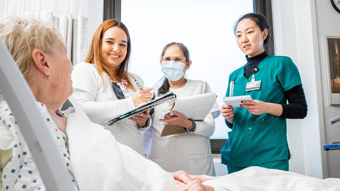 Nurses talking to patient at the bedside