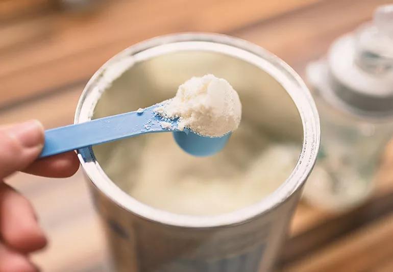 Baby formula being scooped out of a container