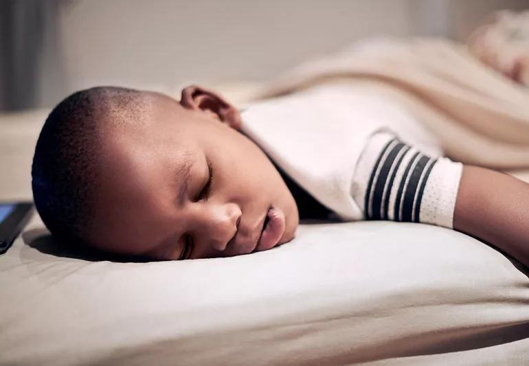 Child snoring during his nap while sleeping on his front.