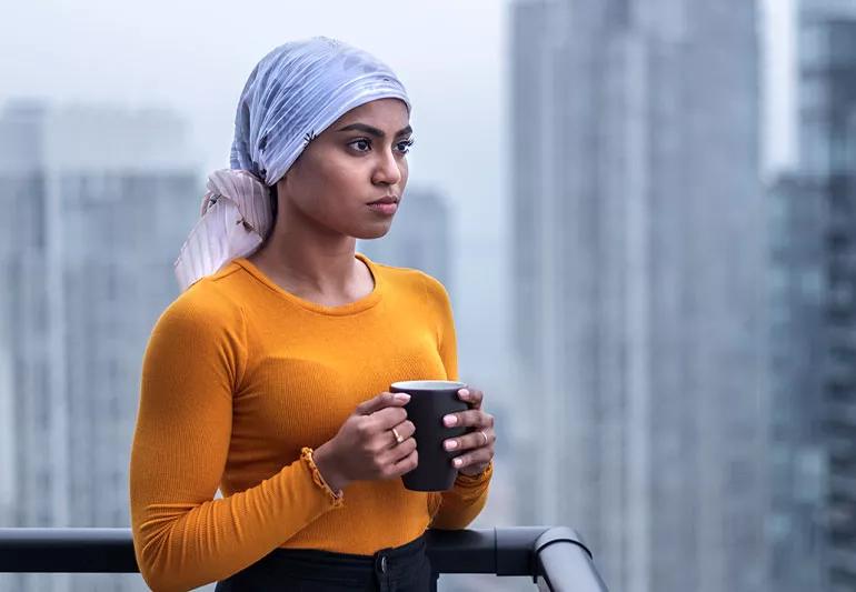 Cancer patient on balcony drinking tea