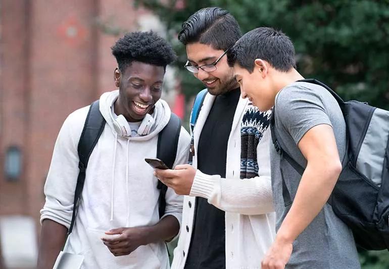 college students looking at a cell phone