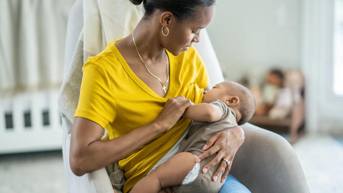 Female breastfeeding in baby's room