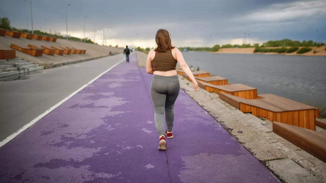 Girl who is overweight walking on a track