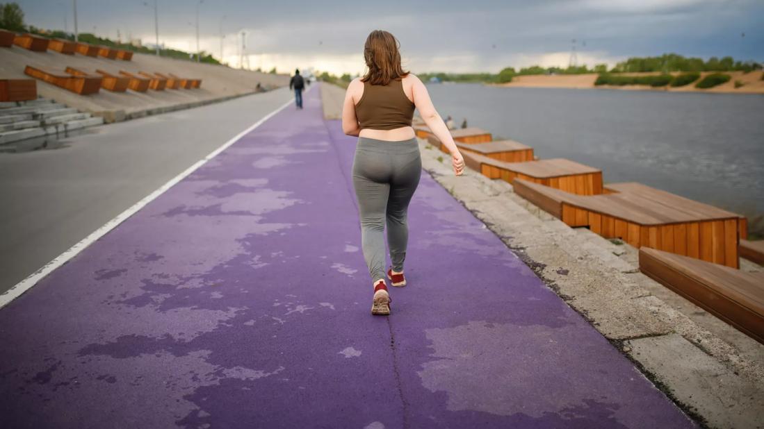 Girl who is overweight walking on a track