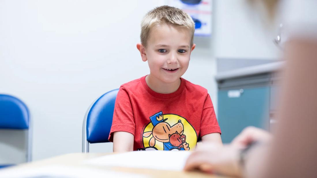 Young boy using alternative communication device