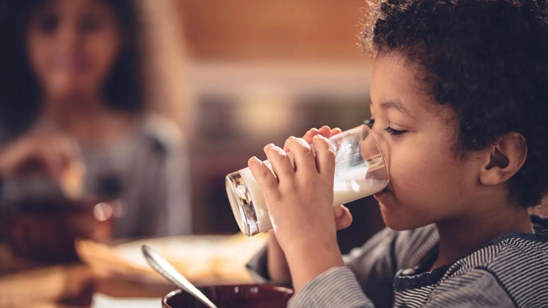 Child drinking a glass of milk at breakfast