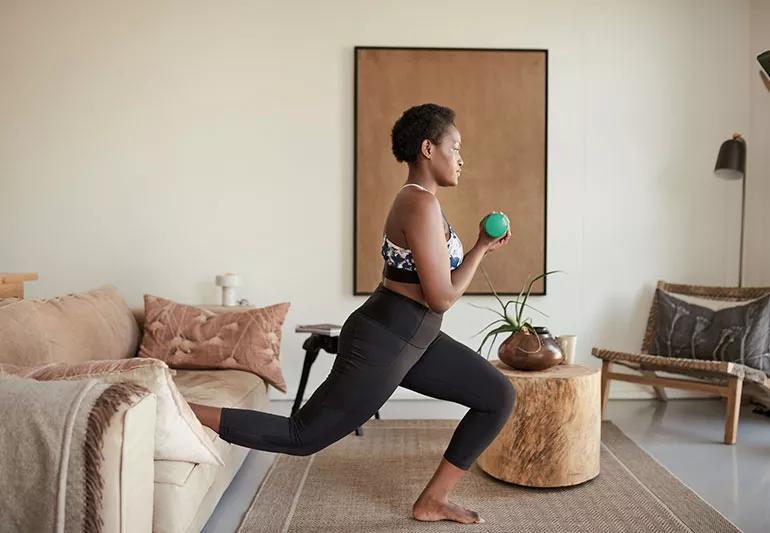 Person exercising with weights in a living room