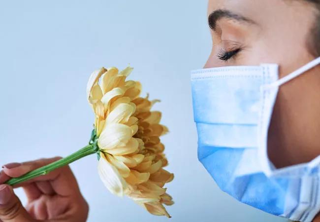 Smelling flower with face mask