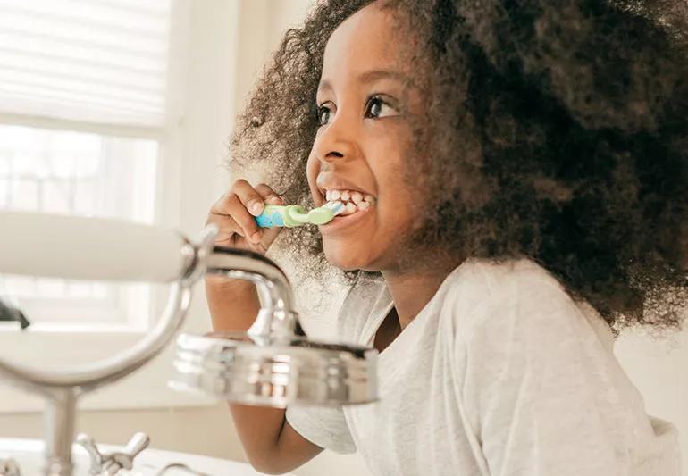 Child brushing her teeth