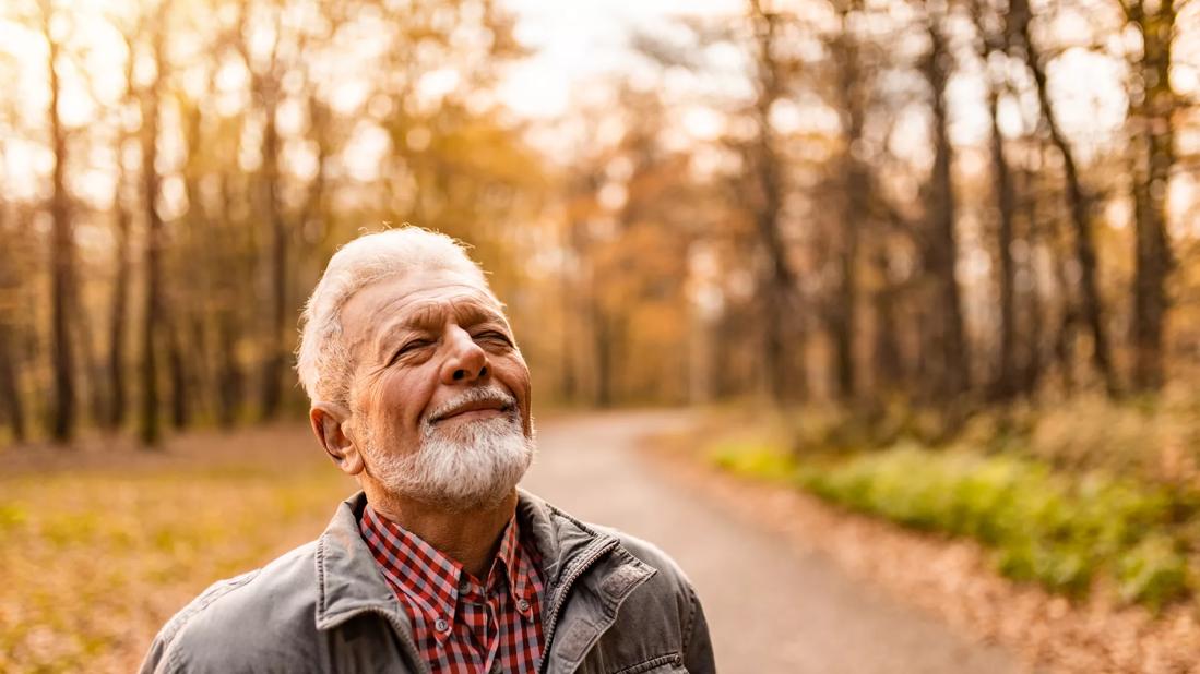 Older person smiling, taking in the outdoors