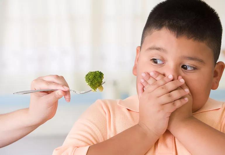 Young boy doesn't want to eat his broccoli