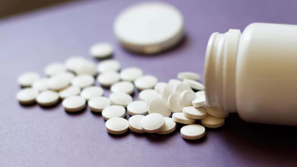 Aspirin poured onto table from bottle