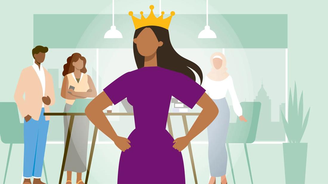 Person standing in workplace with hands on hips, wearing crown, with diverse coworkers