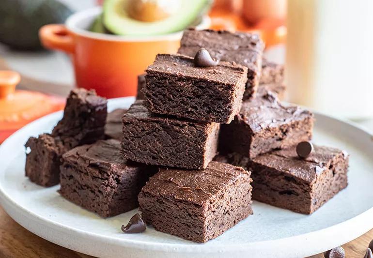 Stack of chocolatey brownies on a white plate