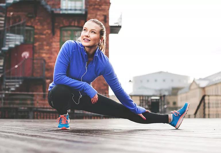 woman stretching before running in fall