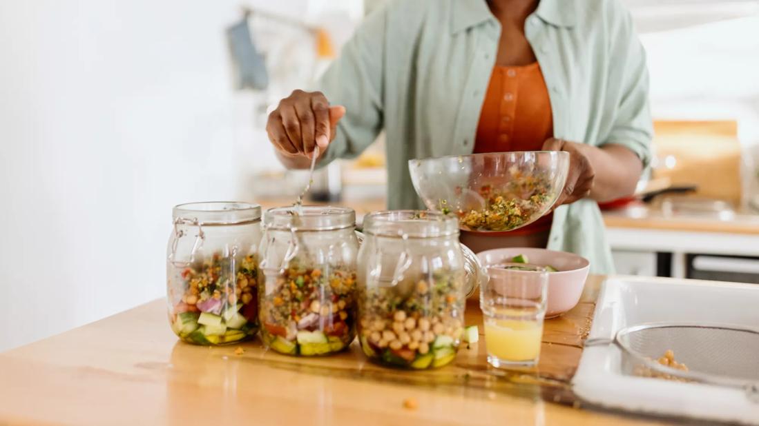 Person prepping mason jars with meals