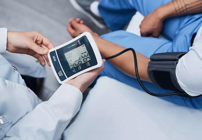 Doctor checks blood pressure of patient in his office