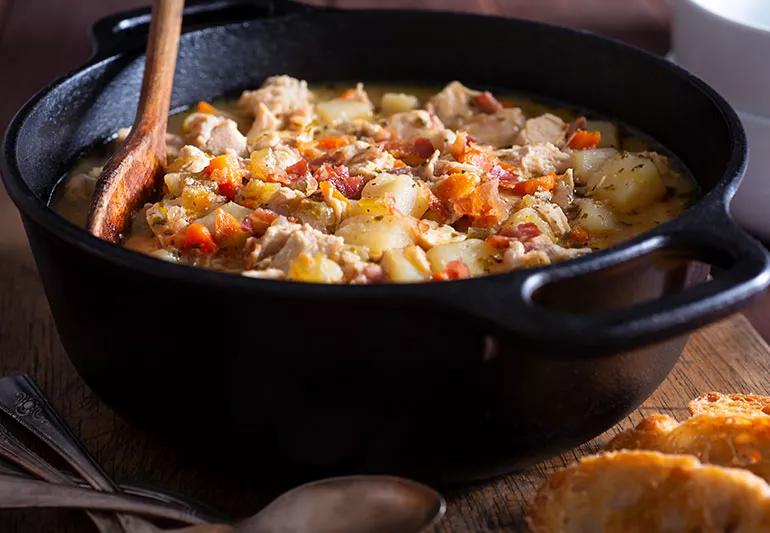 A bowl of hearty chicken soup with potatoes and vegetables