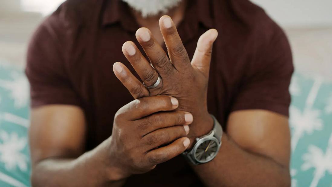 Person holding hand up, massaging it