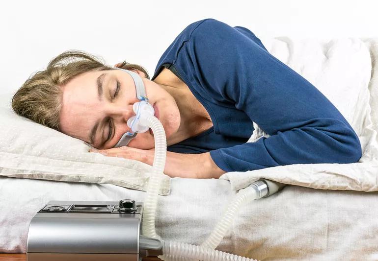 woman using pap machine while sleeping