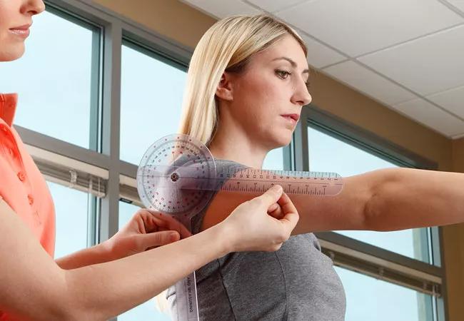 A caregiver measuring a woman's arm to assess her health and body measurements.