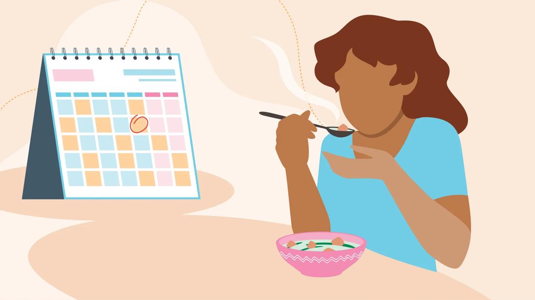 Person eating while looking at certain date circled on calendar