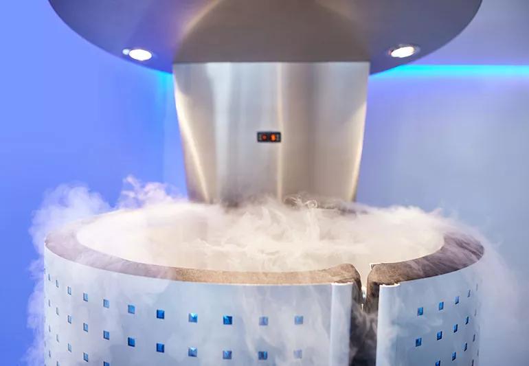 A silver machine with a circular pool with what looks like white smoke swirling out from it