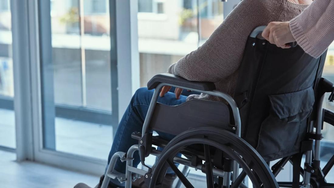 older women being pushed in wheelchair in hospital