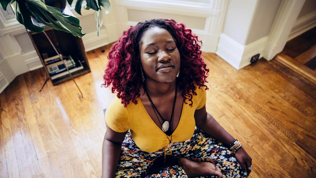 Person relaxing in a seated yoga pose at home