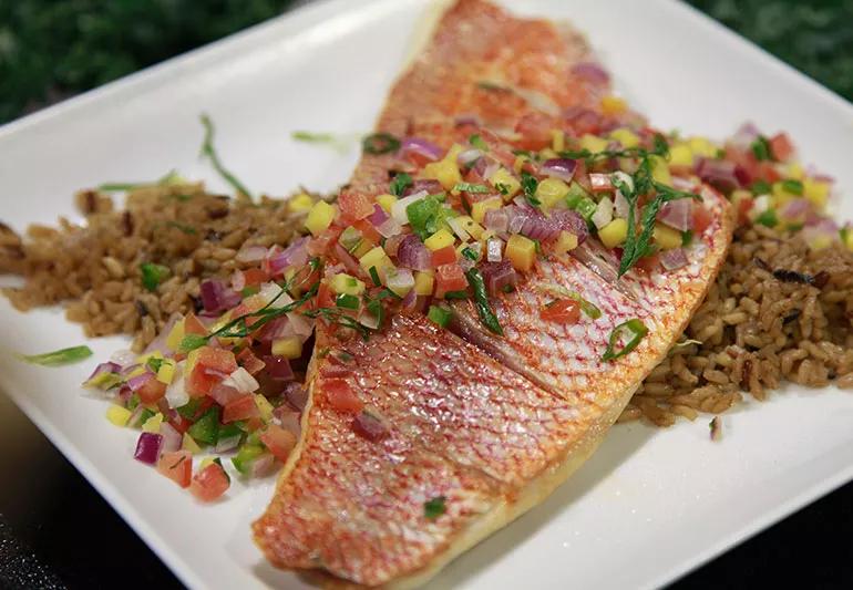 A plate with orange roughy, rice and diced vegetables