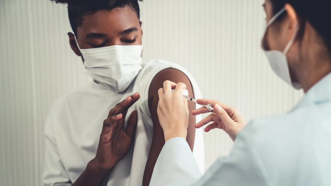 Young man receiving injection with hesitation