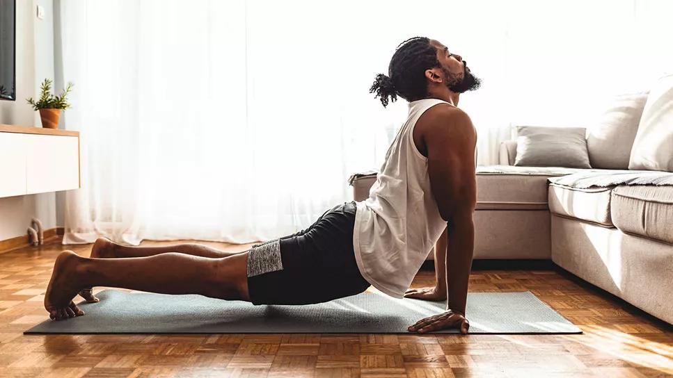 male in a yoga pose in living room