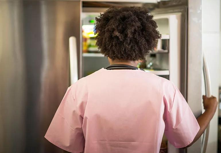 Person opening a refrigerator door and looking inside