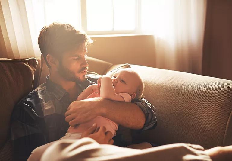 Father holding his daughter on the couch