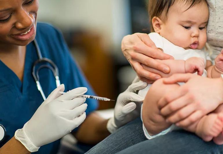 Baby receiving vaccination from healthcare provider.