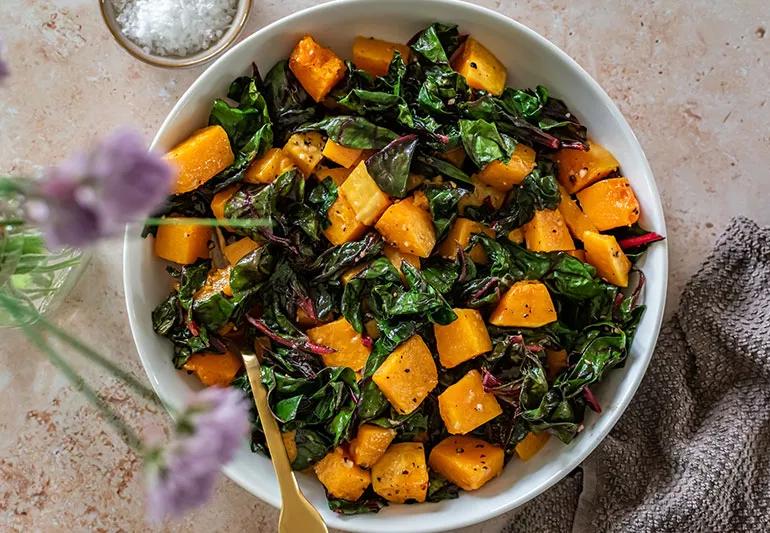 A close up of chard and roasted butternut squash in a bowl